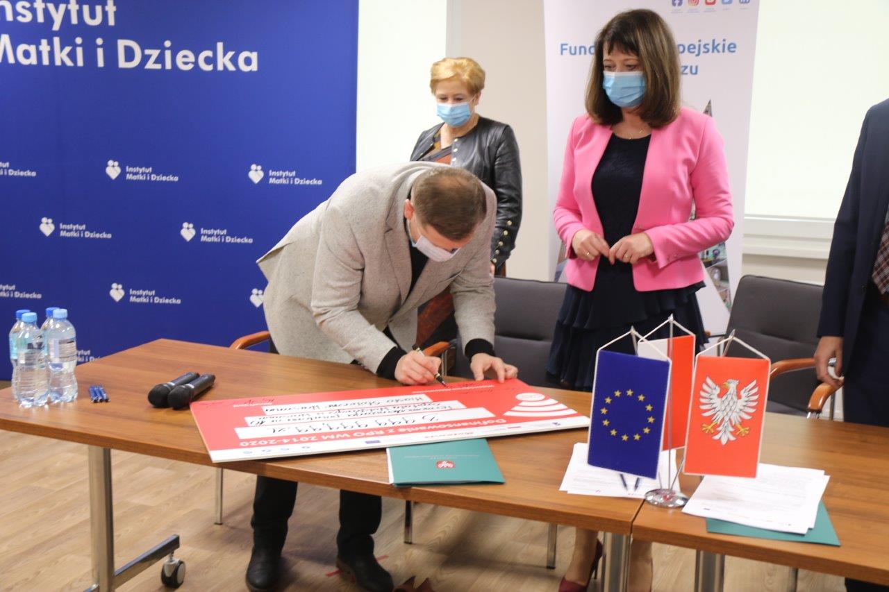 Podpisanie pamiątkowego czeku przez Pana Krzysztofa Strzałkowskiego radnego województwa mazowieckiego